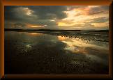 Sunset reflected in the sea at low tide, St Ninian's Bay, Isle of Bute, Scotland.